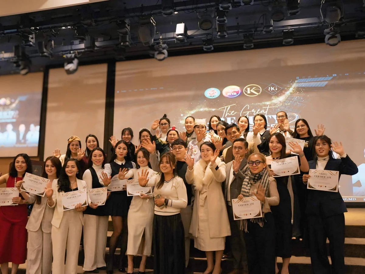 Nhóm người cầm giấy ghi Certificate và chụp ảnh trước màn hình sự kiện.