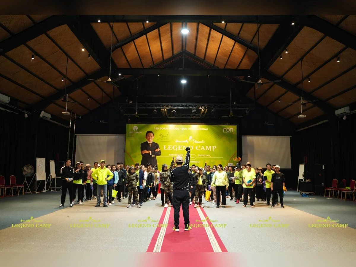 Nhóm người tham gia hoạt động trong hội trường trước phông nền Legend Camp.