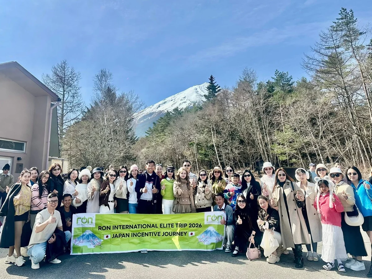 Đoàn RON INTERNATIONAL® chụp ảnh ngoài trời cùng băng-rôn Japan Incentive Journey 2026.