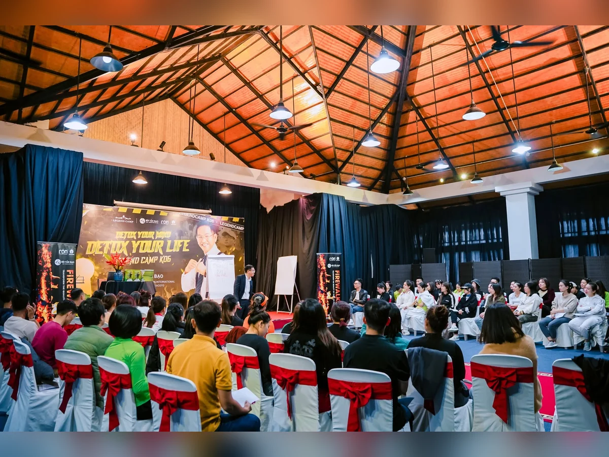 Người tham dự ngồi thành vòng quanh diễn giả và các bảng giấy trong phòng có phông LEGEND CAMP K06.