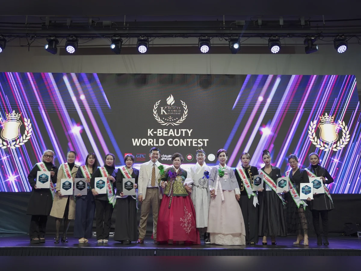 Nhóm người đeo dải băng và cầm bảng ghi nhận trên sân khấu K-Beauty World Contest.