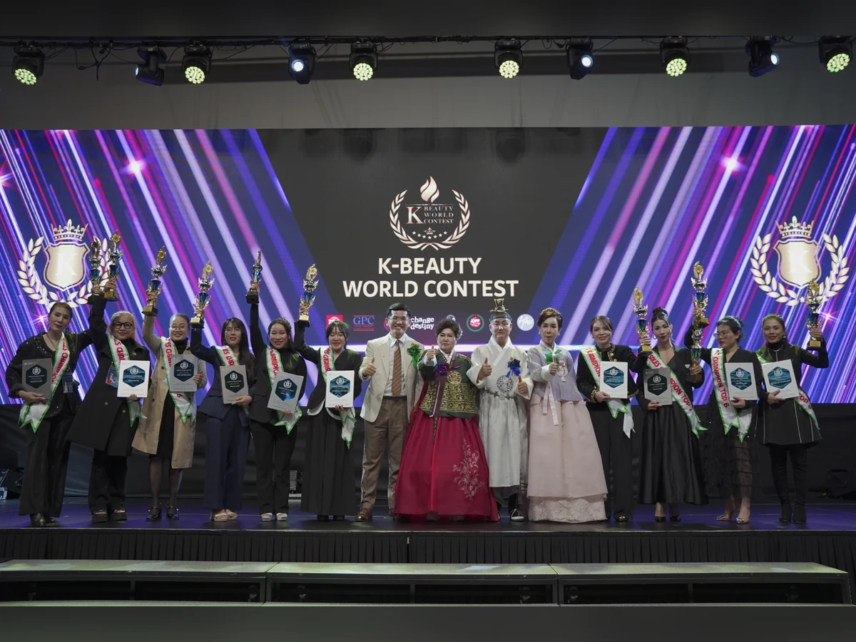 Nhóm người giơ cúp và cầm bảng ghi nhận trên sân khấu K-Beauty World Contest.