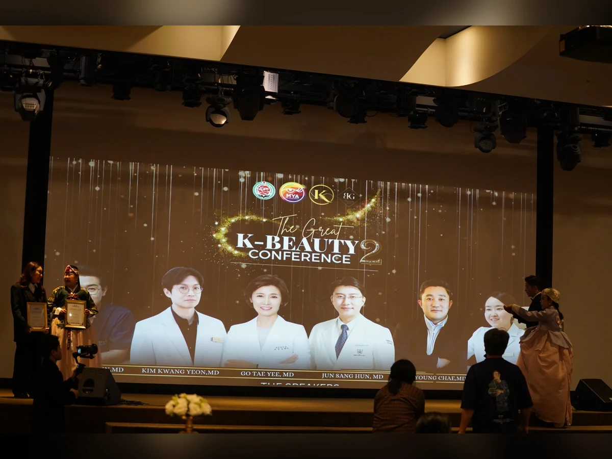 Những người cầm khung ghi nhận đứng trên sân khấu có màn hình The Great K-Beauty Conference 2.