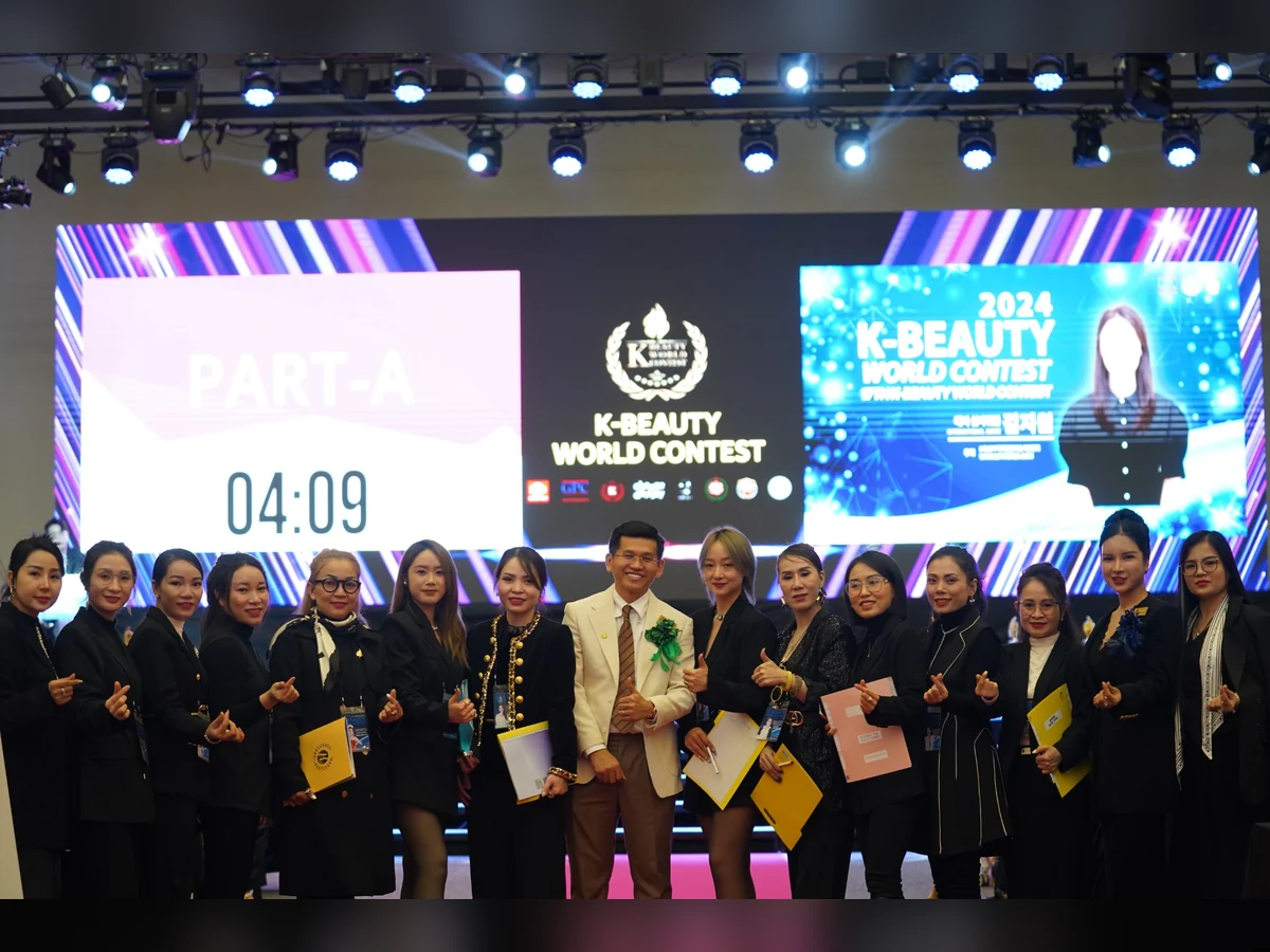Nhóm người chụp ảnh trước màn hình K-Beauty World Contest 2024, nhiều người cầm hồ sơ.